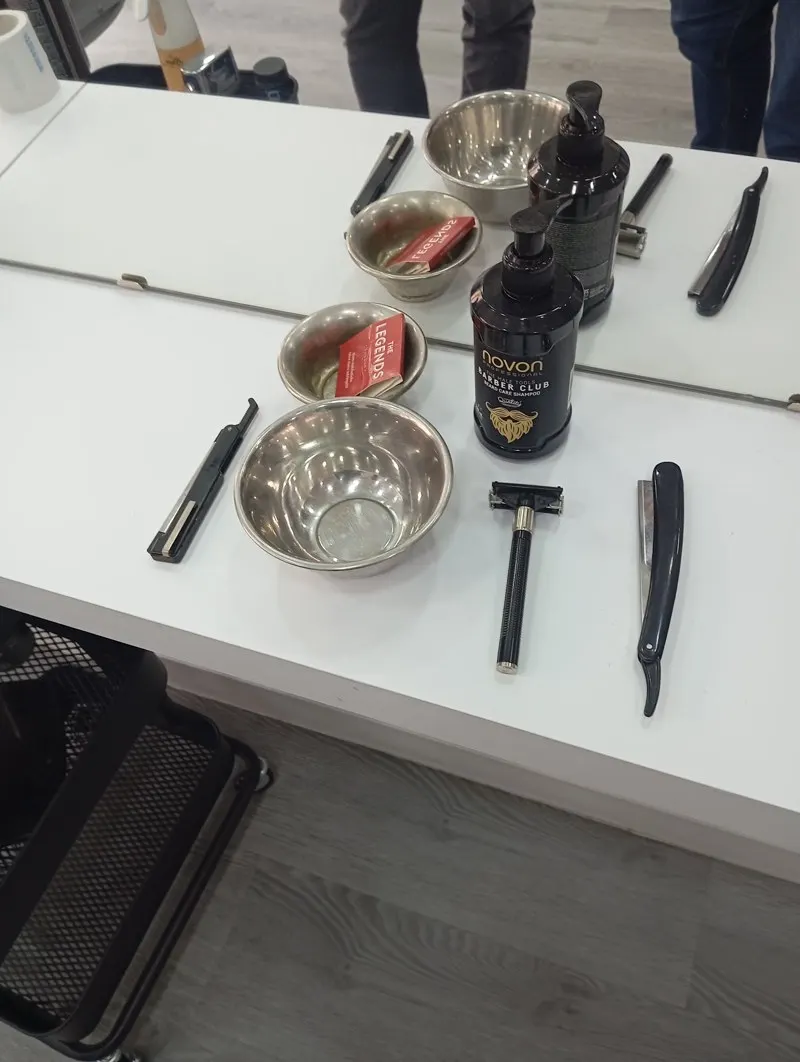 Tocador con navajas y brochas de afeitado en la barbería